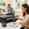 A woman smiles while inserting the Balloon Brand Cyan LC404 ink cartridge into a Brother INKvestment printer in a bright home office.
